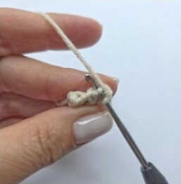 Crochet process of a handmade bunny amigurumi showing yarn loop and hook during soft toy construction
